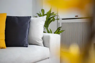 a white couch with a potted plant on it at AthensBlues Kolonaki 2 Bedroom with Car Park in Athens