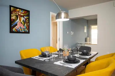a dining room with a table and yellow chairs at AthensBlues Kolonaki 2 Bedroom with Car Park in Athens