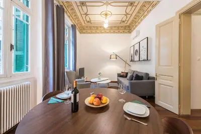 a table with a bowl of fruit on it in a living room at Mavrogenous - The Mansion in Athens