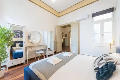 a bedroom with a large bed and a mirror at Mavrogenous - The Mansion in Athens