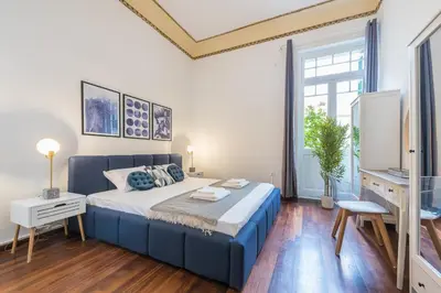 a bedroom with a blue bed and a tv at Mavrogenous - The Mansion in Athens