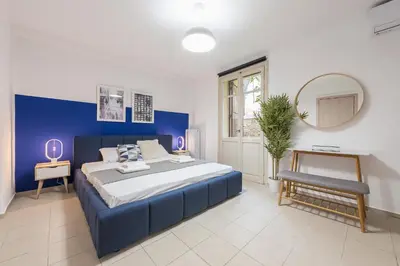 a blue and white bedroom with a bed and a mirror at Mavrogenous - The Mansion in Athens