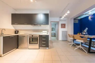 a kitchen with stainless steel appliances and a dining table at Mavrogenous - The Mansion in Athens