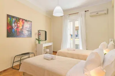 a hotel room with two beds and a desk at Venias Two-Bedroom apartment Kallimarmaro and Zappeio area in Athens