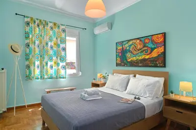 a blue bedroom with a bed and a painting on the wall at Venias Two-Bedroom apartment Kallimarmaro and Zappeio area in Athens