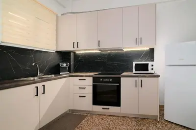 a kitchen with white cabinets and a microwave at Venias Two-Bedroom apartment Kallimarmaro and Zappeio area in Athens