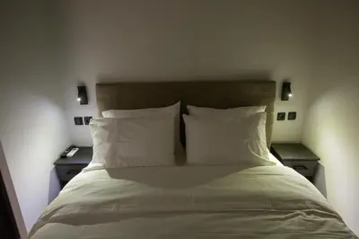 a bed with white sheets and pillows in a room at Raise Acropolis View Suites in Athens
