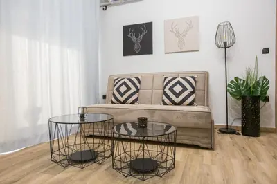 a living room with two tables in front of a couch at Raise Acropolis View Suites in Athens
