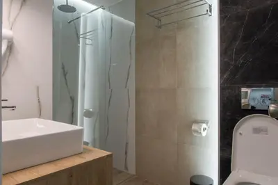 a bathroom with a white sink and a shower at Koios Apartments in Athens