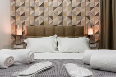 a bedroom with a bed with two towels on it at Koios Apartments in Athens