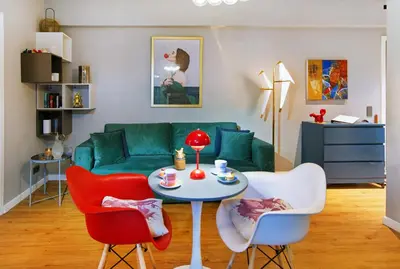 a living room with a green couch and a table and chairs at Five Seasons Alimos in Athens