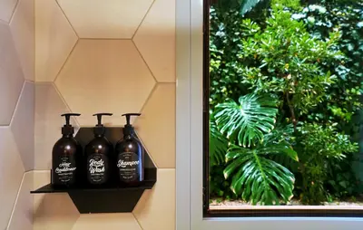 a shelf with three bottles on it next to a window at Five Seasons Alimos in Athens