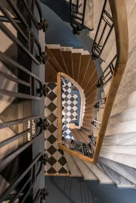 a spiral staircase in a building with a mirror at Cohort Koukaki in Athens