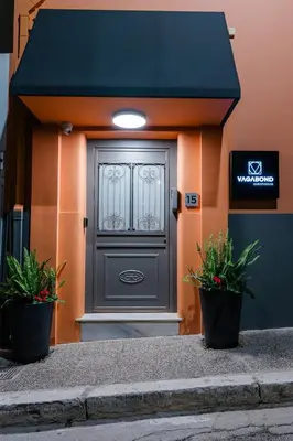 a front door of a building with two potted plants at Vagabond Guesthouse in Athens