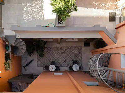 a room with a staircase with a table and a plant at Vagabond Guesthouse in Athens