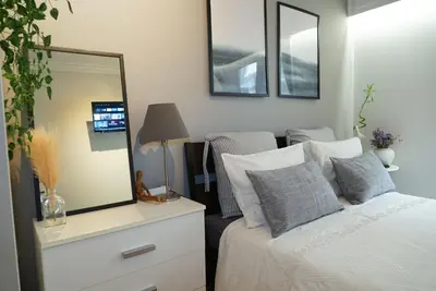 a bedroom with a bed with a dresser and a mirror at Comfy studio apartment very close to city centre in Athens