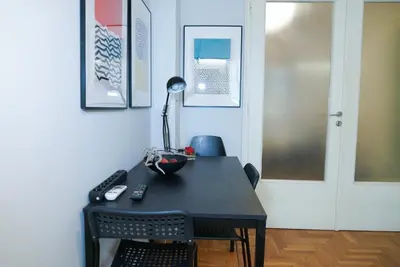 a desk with a lamp and a chair in a room at Comfy studio apartment very close to city centre in Athens
