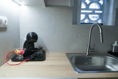a kitchen counter with a mixer and a sink at Comfy studio apartment very close to city centre in Athens