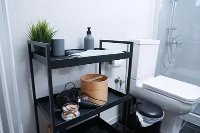 a bathroom with a black shelf next to a toilet at Comfy studio apartment very close to city centre in Athens