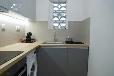 a kitchen with a sink and a washing machine at Comfy studio apartment very close to city centre in Athens