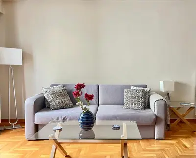 a living room with a couch and a table with a vase at 2 Bedroom Acropolis Apartment in Athens