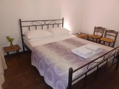 a bedroom with a large bed with two chairs at The monumental house in Athens