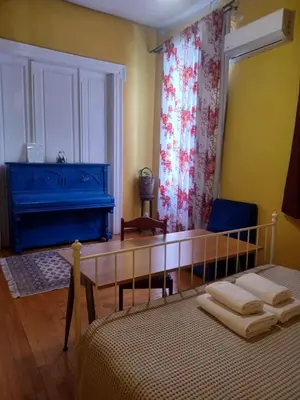 a bedroom with a bed and a blue piano at The monumental house in Athens