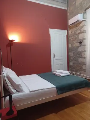 a bed in a room with a red wall at The monumental house in Athens