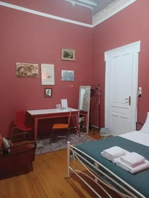 a bedroom with a desk and a bed and a table at The monumental house in Athens