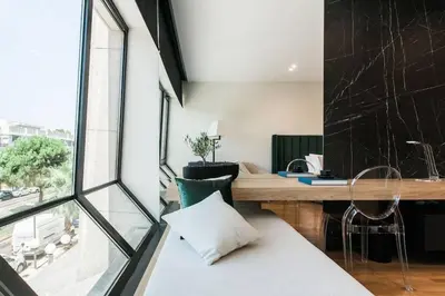 a living room with a desk and a window at 2 SidebySide Suites in Athens Riviera by The Olon in Athens