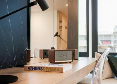 a desk with a clock and a book on it at 2 SidebySide Suites in Athens Riviera by The Olon in Athens