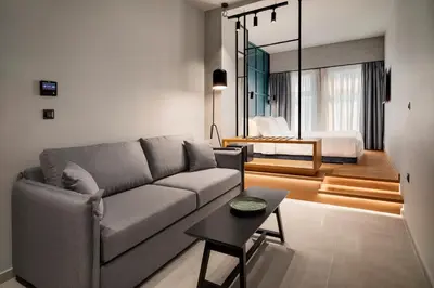 a living room with a couch and a bedroom at Bob W Athens Akadimia in Athens