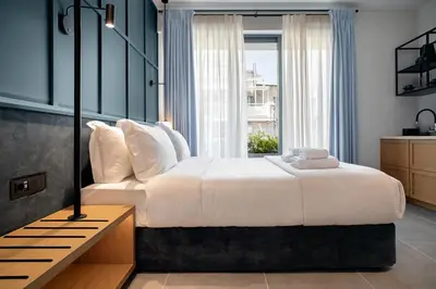 a bedroom with a large white bed and a window at Bob W Athens Akadimia in Athens
