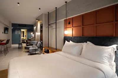 a bedroom with a large bed and a living room at Bob W Athens Akadimia in Athens