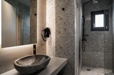 a bathroom with a large stone sink and a shower at Bob W Athens Akadimia in Athens