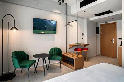 a room with green chairs and a table at Bob W Athens Akadimia in Athens