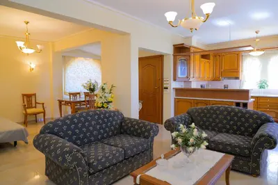 a living room with two couches and a table at GREEN PARADISE PALAIA FoKAIA in Áyios Yeóryios