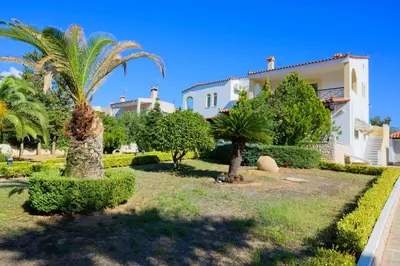 a house with a palm tree in the yard at GREEN PARADISE PALAIA FoKAIA in Áyios Yeóryios