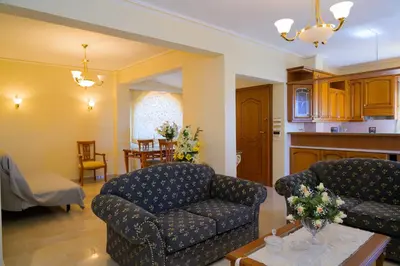 a living room with a couch and a table at GREEN PARADISE PALAIA FoKAIA in Áyios Yeóryios