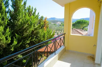 a balcony with a view of a pine tree at GREEN PARADISE PALAIA FoKAIA in Áyios Yeóryios