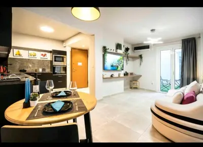 a living room with a table and a kitchen at DELUXE ROMANTIC JACUZZI in Athens