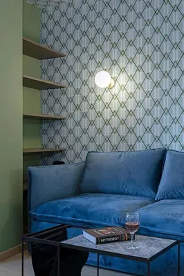 a blue couch in a living room with a table at Acro Urban Suites in Athens
