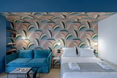 a living room with two beds and a blue couch at Acro Urban Suites in Athens