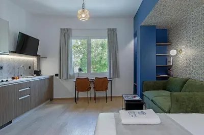 a living room with a green couch and a kitchen at Acro Urban Suites in Athens