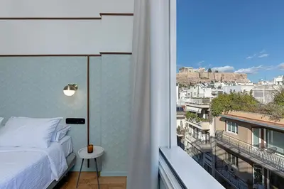 a bedroom with a bed and a view of a city at Acro Urban Suites in Athens