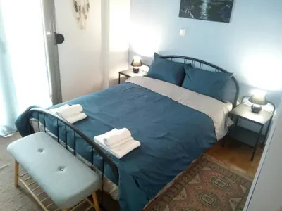 a bedroom with a blue bed and a chair at Teros apartment in Athens