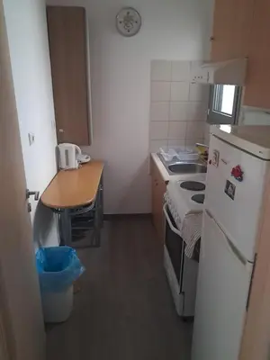 a small kitchen with a white refrigerator and a table at Teros apartment in Athens