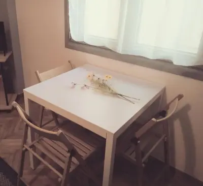 a white table and two chairs with flowers on it at Teros apartment in Athens