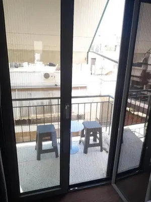 a view of a balcony with two benches through a window at Teros apartment in Athens