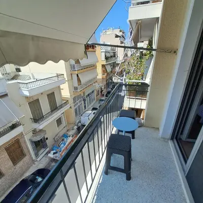 a balcony with a table and chairs in a building at Teros apartment in Athens